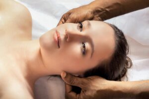 woman laying on massage table getting head massage